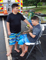 twin boys stroking lizard from reptile zoo