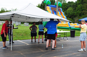 members of Ebenezer having trouble setting up a large canopy