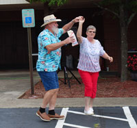 an older man and woman dancing to music