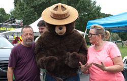 man and woman on each side of Smokey the Bear